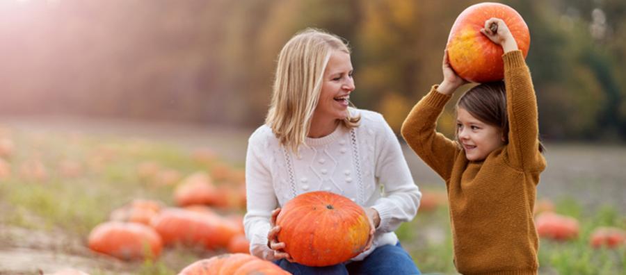 mother and daughter in pumpkin patch